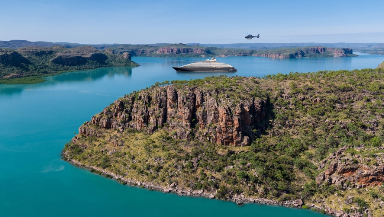 luxury ocean cruise discovery yacht sailing in the blue waters of the kimberleys in Australia with a helicopter flying over head