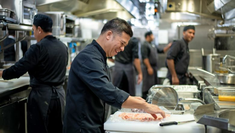 Kitchen hand assisting with prep in a kitchen onboard a luxury ocean cruise vessel