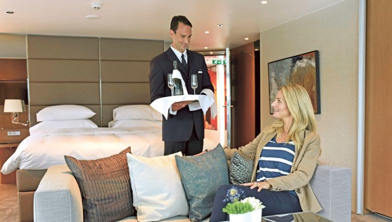 river cruise butler serving a guest in their suite