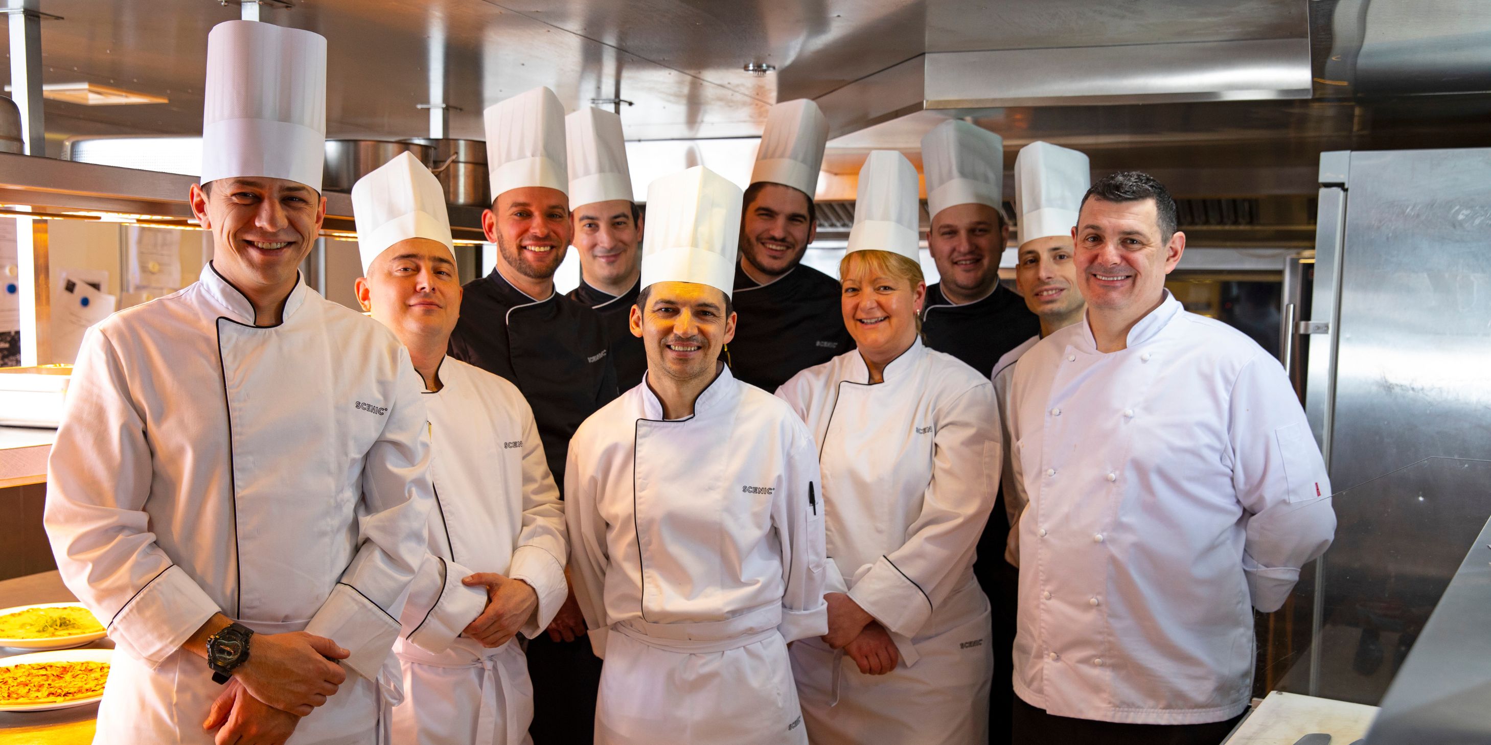 Group of the Kitchen Crew posing for a photo in their uniforms